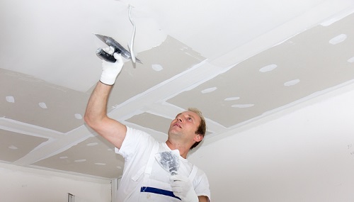 Plasterer plastering ceiling