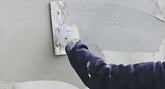 Plasterer adding second coat